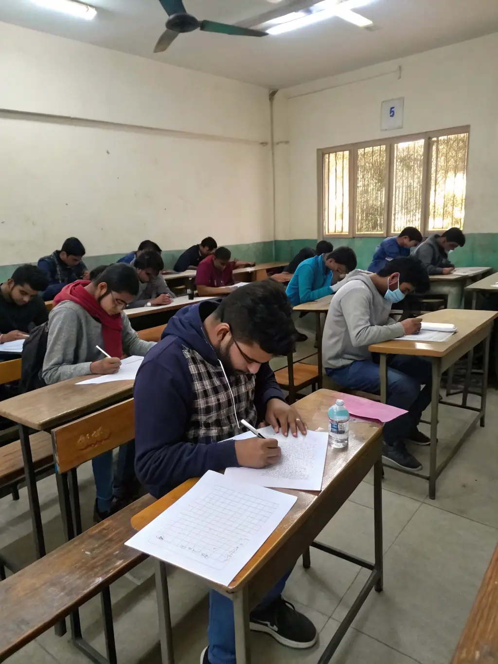 A student confidently taking a final exam, with a focused expression and a clear understanding of the material, in a quiet and well-equipped examination hall, highlighting the importance of thorough exam preparation.